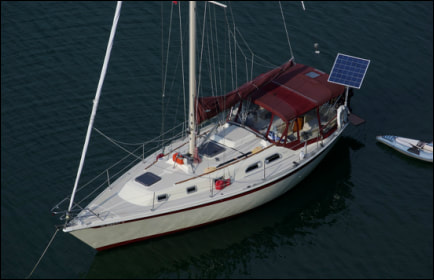 Sailboat with rigid marine solar panel mounted with top of pole solar mounting system